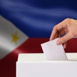 Voters casting ballots in a 2025 election with diverse participants at a polling station.