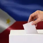 Voters casting ballots in a 2025 election with diverse participants at a polling station.